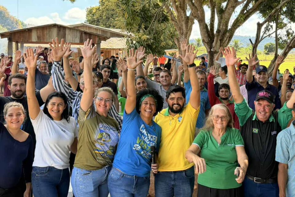 Moradores levantam as mãos durante encontro político em Rondônia