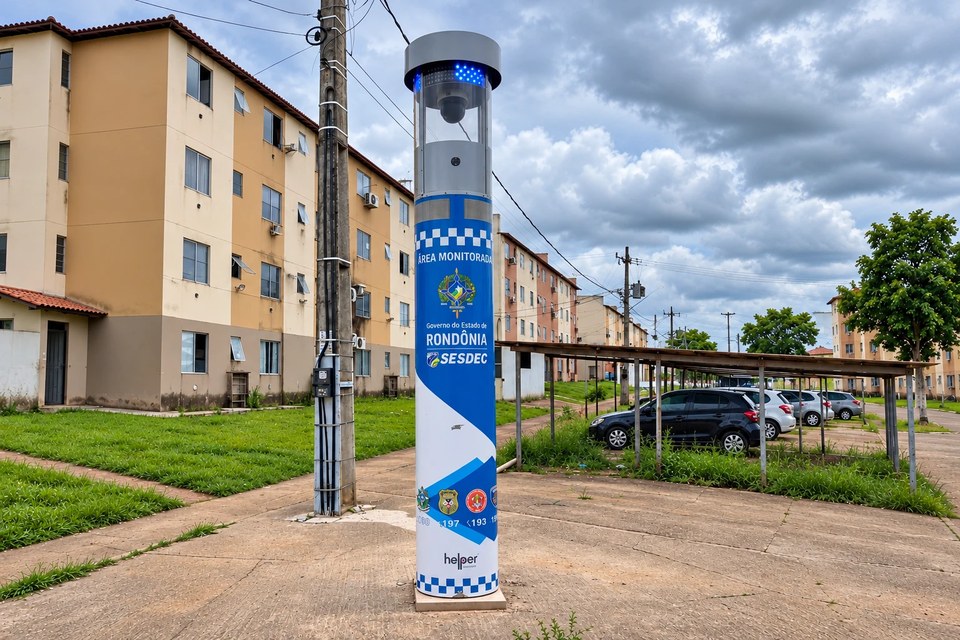 Totem de segurança instalado em área de conjunto habitacional, com prédios residenciais ao fundo
